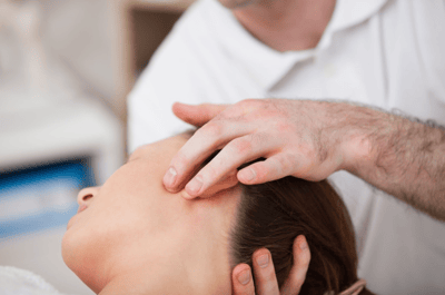 Chiropractor treating patient with headache