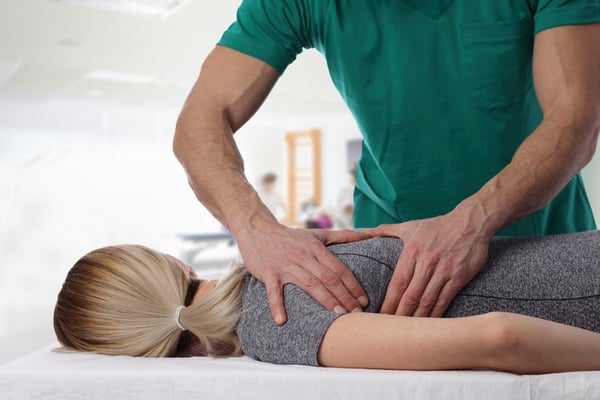 Chiropractor Adjusting Woman's Back