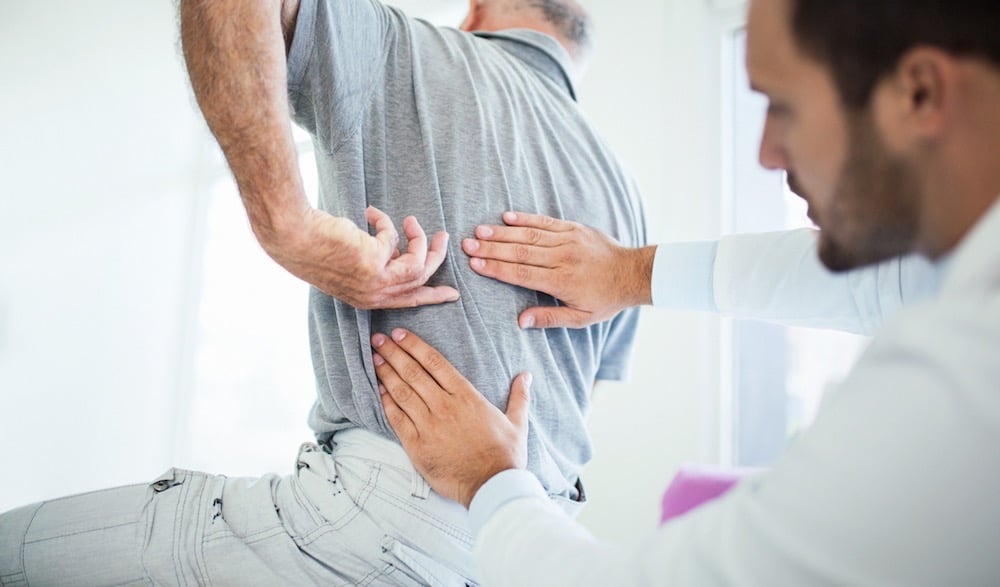 Chiropractor Adjusting a Man's Lower Back